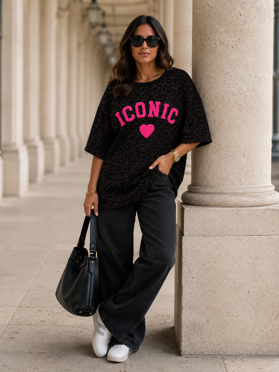 Oversize Sweatshirt mit Leopardenprint und pinkem ICONIC-Schriftzug – Frontansicht, getragen von einer Frau vor Säulen
