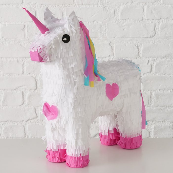 Einhorn Piñata vor weißer Backsteinwand, Seitenansicht